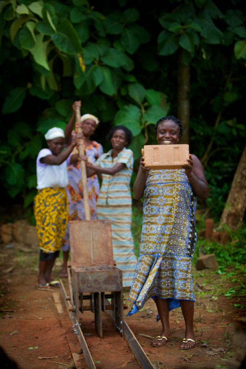 Village women making bricks by hand for new village enter